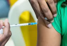 Profissinal da área da saúde aplica vacina em criança