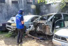 Agente olhando carcaça de automóveis