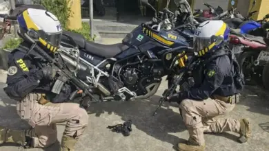 Agentes do Grupo de Motociclismo Policial da PRF exibem a arma apreendida durante ação